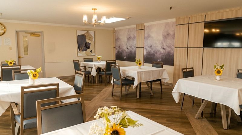 Bright dining room with white tablecloths and fresh sunflowers