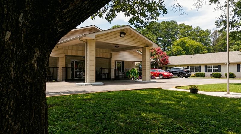 Covered front entrance of Brookshire, shaded by a large oak tree