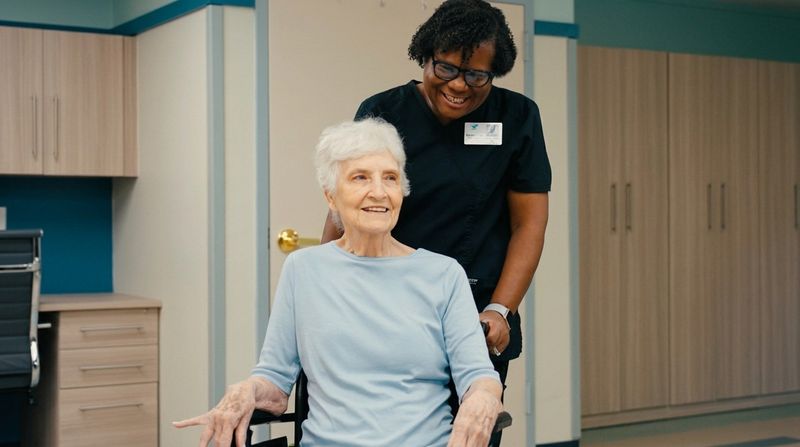A smiling resident with a Brookshire nurse
